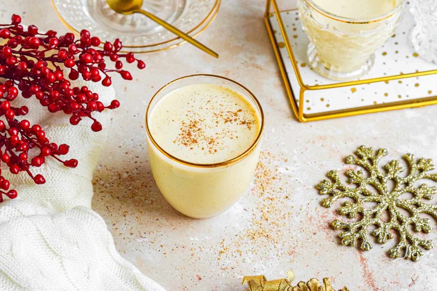 Homemade eggnog in a gold rimmed glass.