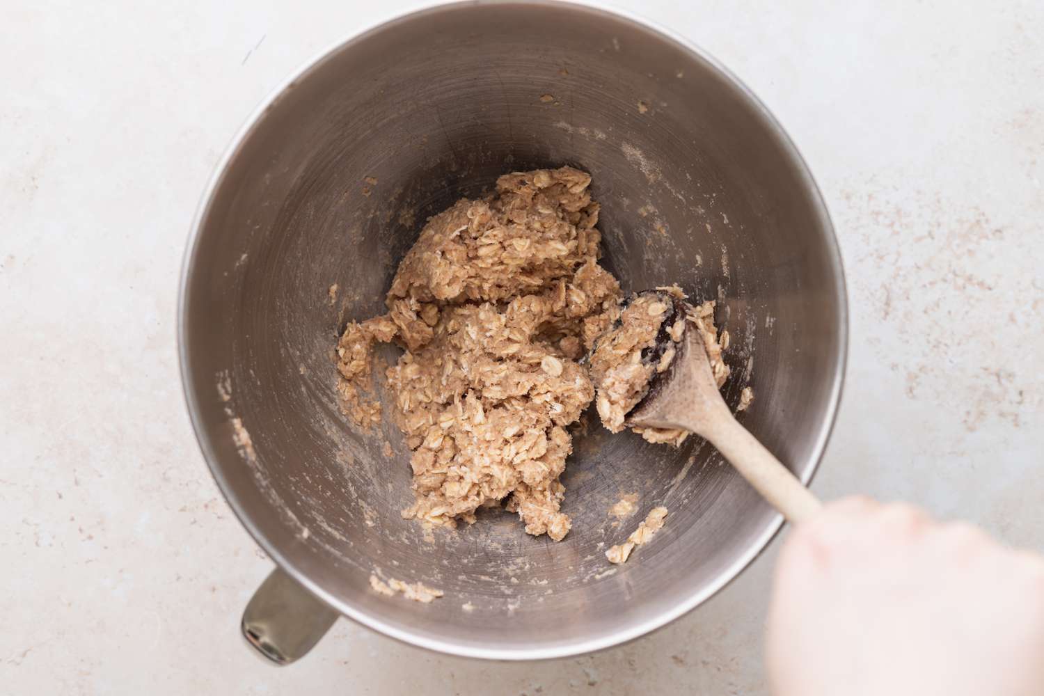 Overhead view of a metal bowl with ingredients to show how to make oat bread.