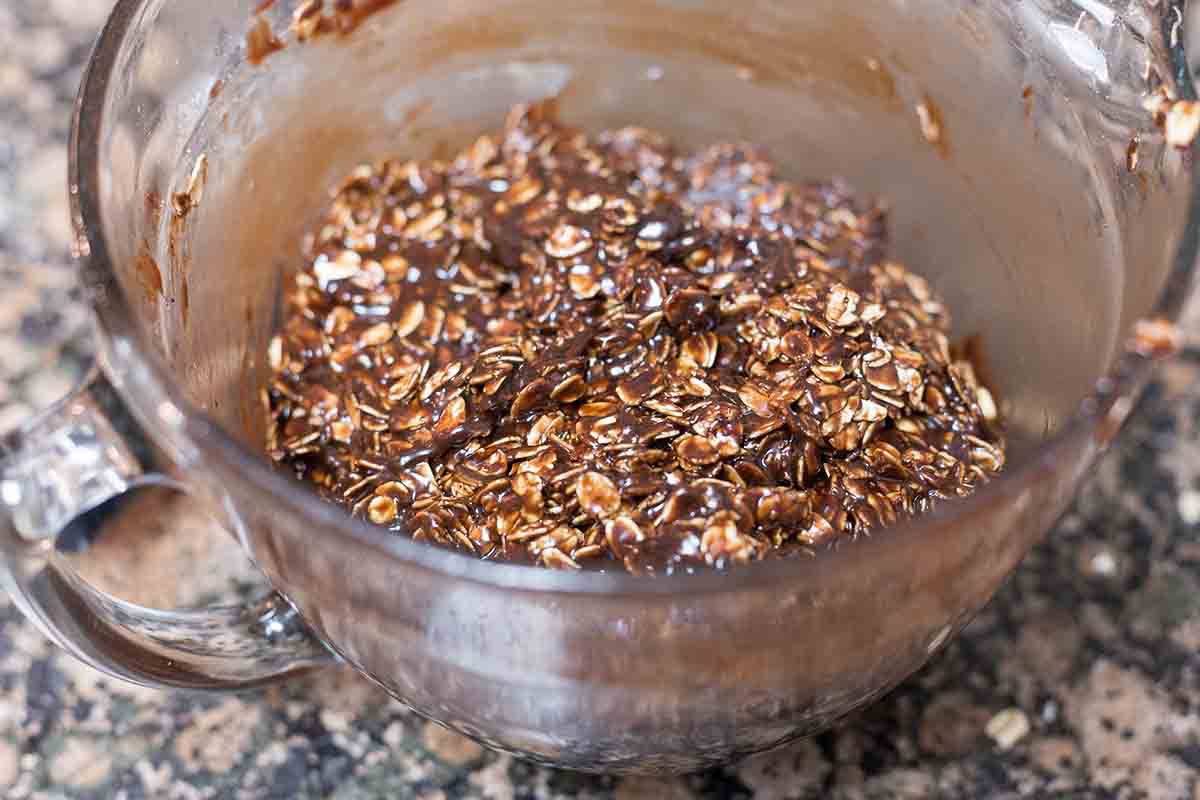 Oats mixed in with chocolate and peanut butter to make peanut butter no bake cookies.