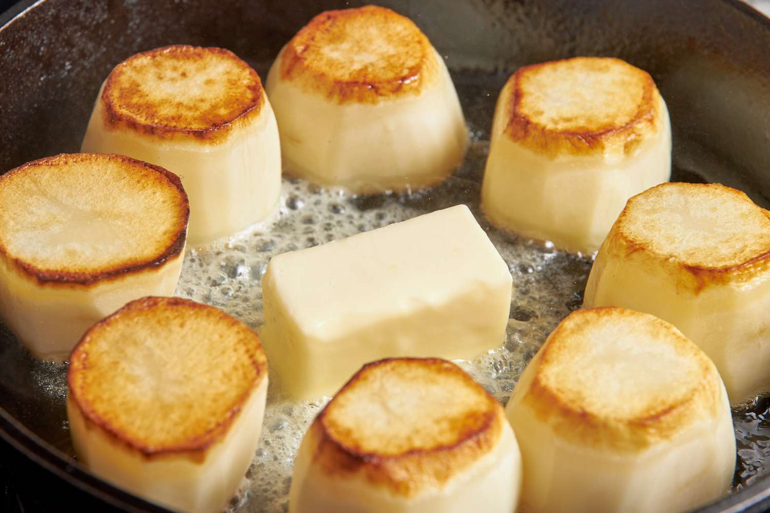 A block of butter added to the middle of skillet (potatoes still on the skillet) for fondant potatoes recipe