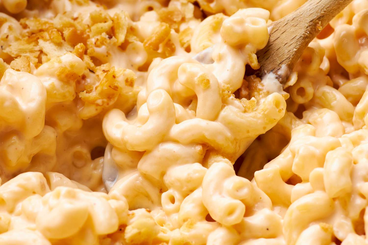 mac and cheese mixed using a wooden spoon (close-up)