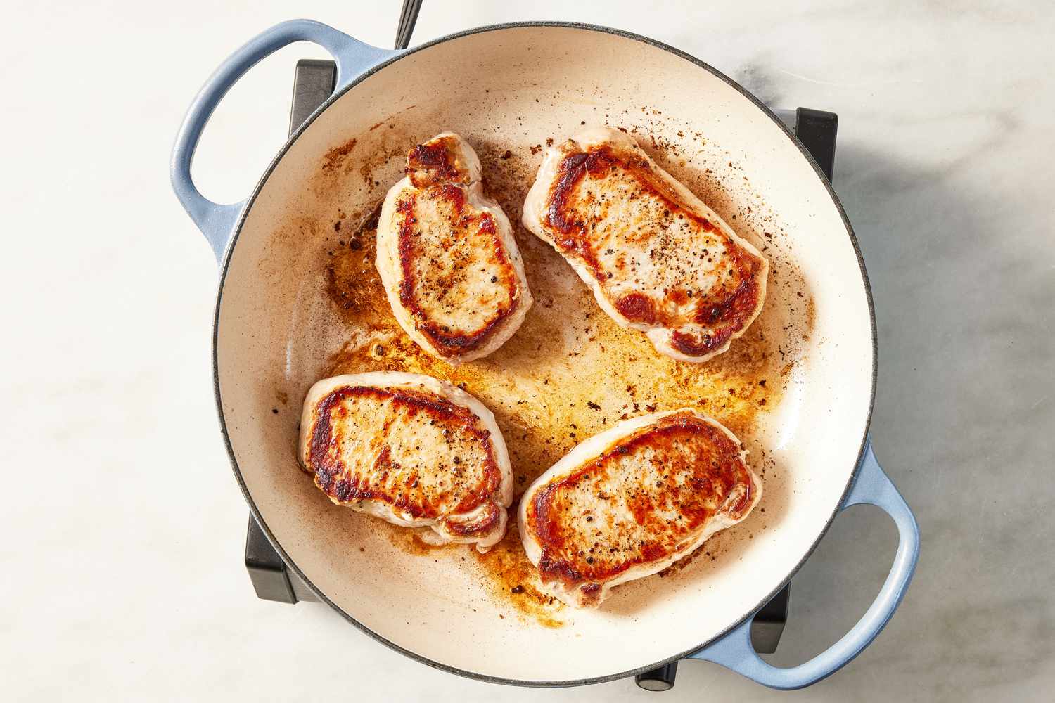 pork chops cooked in a wide skillet for glazed pork chops recipe