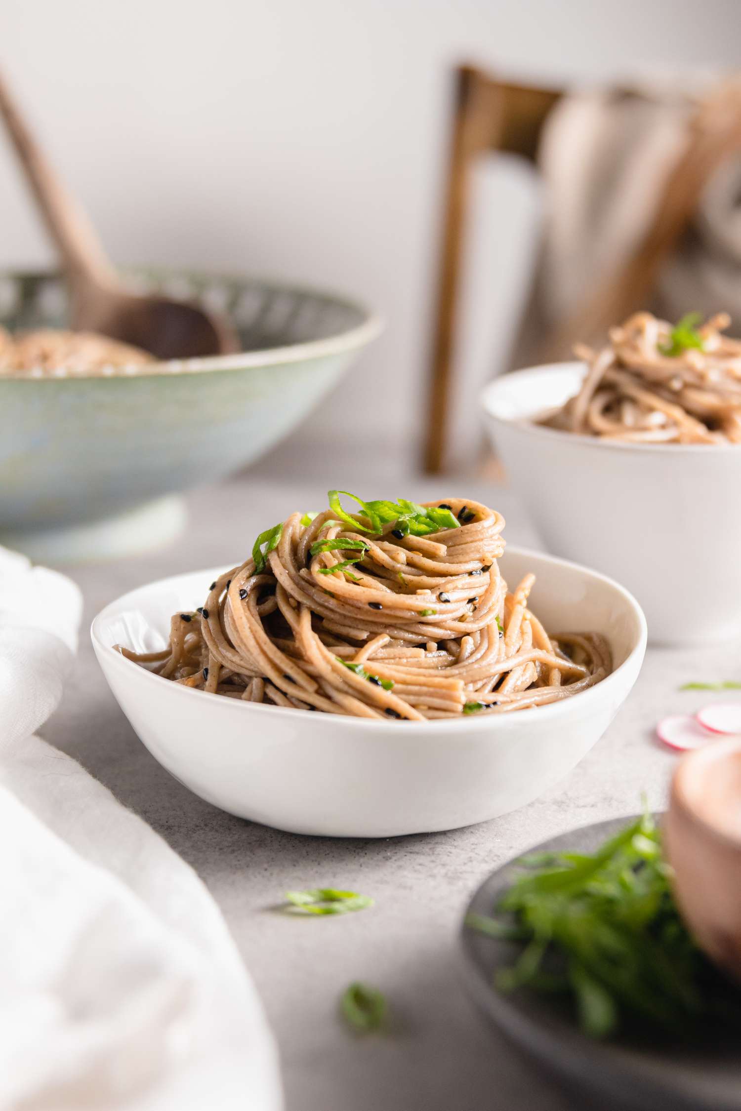 Sesame Soba Noodles in a Bowl Surrounded by More Bowls of Noodles