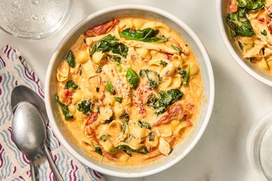 Overhead view of a white bowl of Marry Me Chicken Soup with a two spoons and a napkin to the left