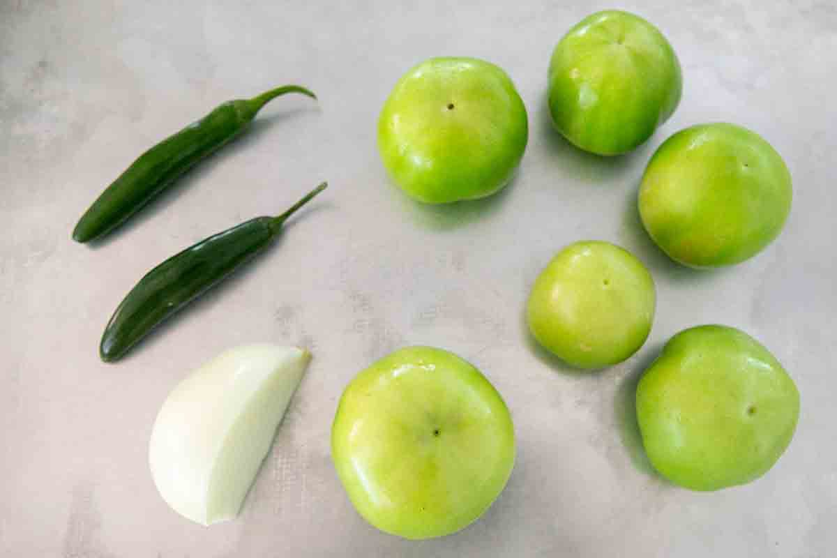 green chiles tomatillos and onion slice on baking pan