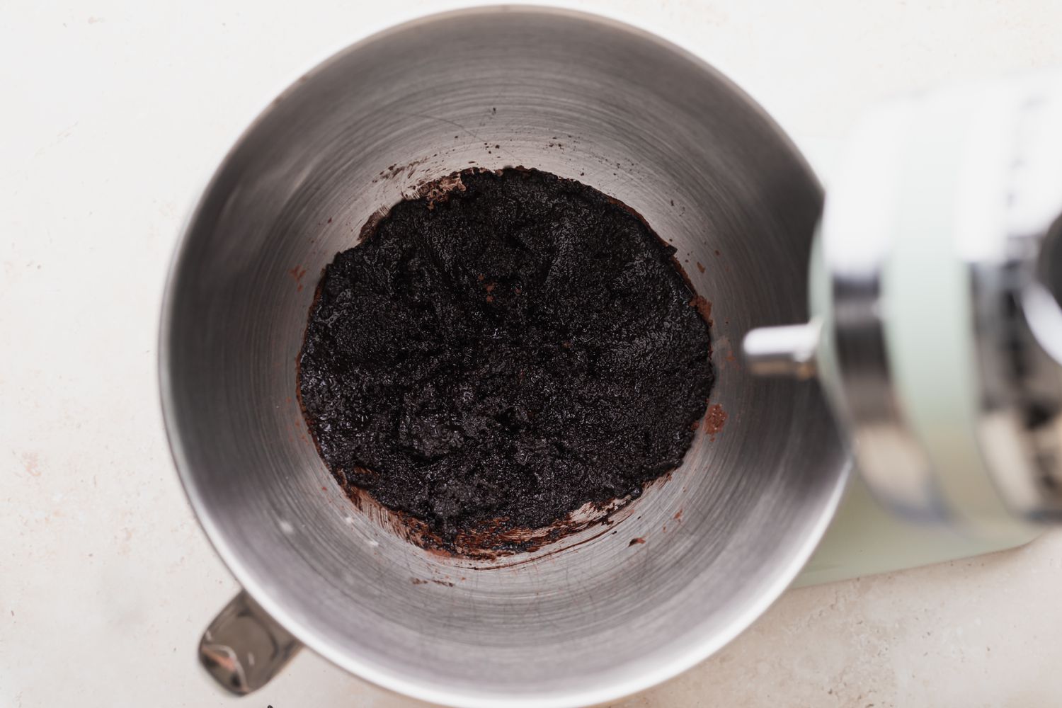 Cocoa powder, white sugar, and vegetable oil mixed together in a stand mixer