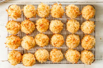 Overhead view of a cooling rack of twenty four macaroon cookies on a wooden table background