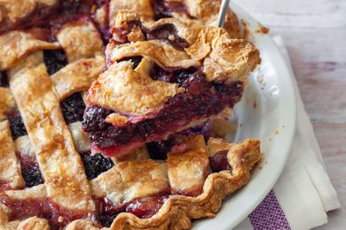 Blackberry Pie in a Pie Dish with a Slice Raised on a Pie Server