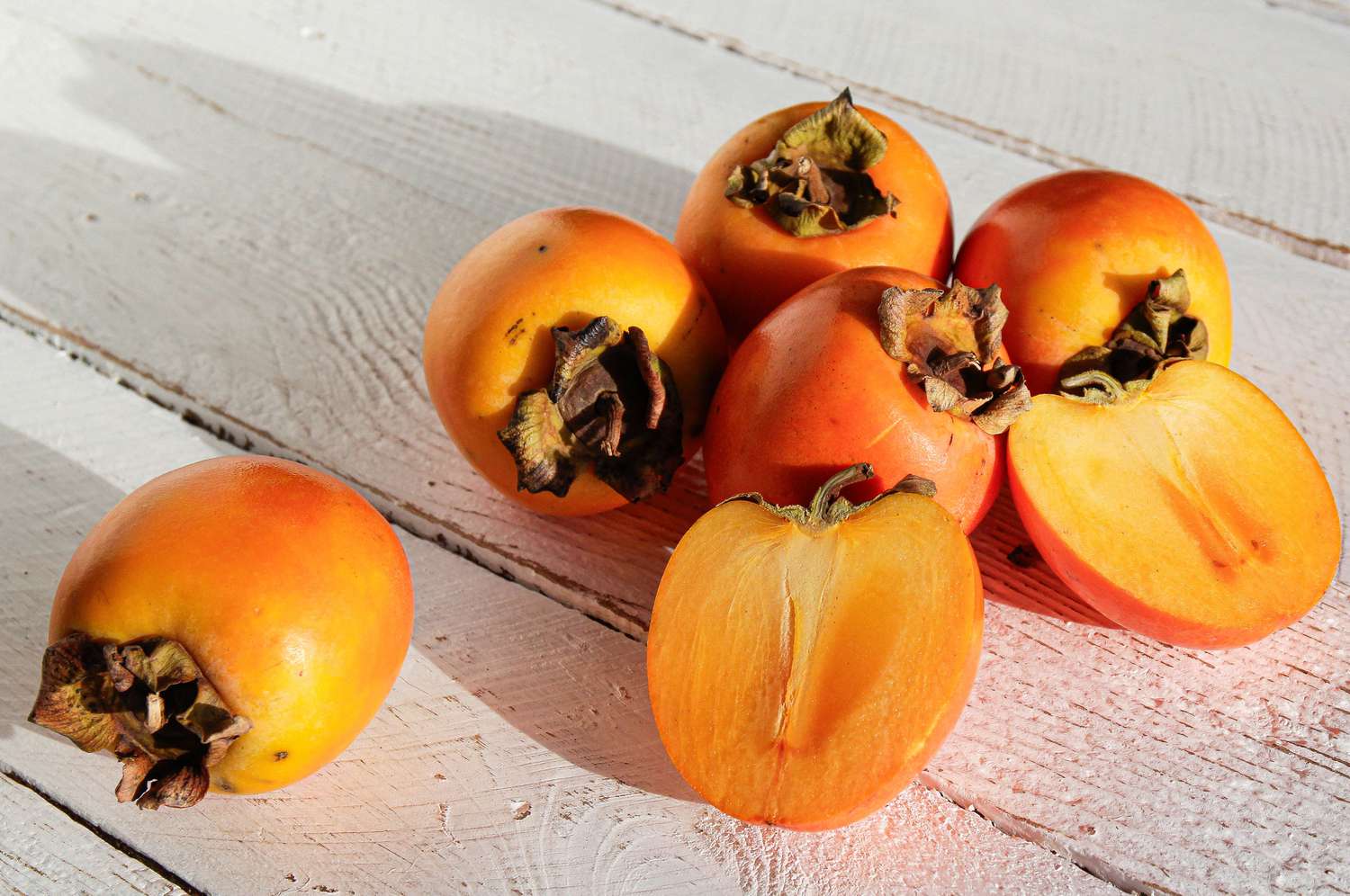 Persimmons, one cut in half