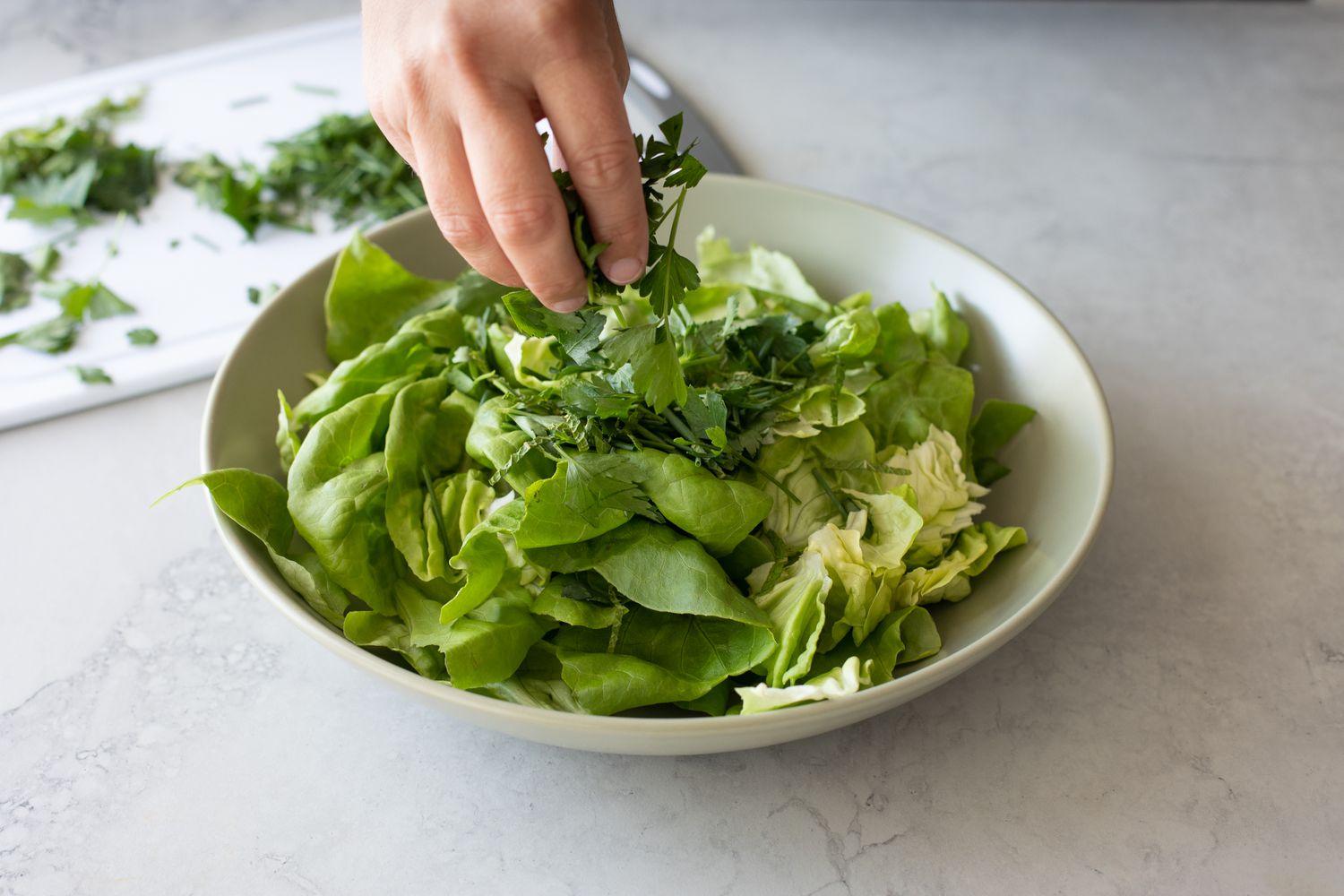 Fresh Herbs Added to Bowl of Lettuce for Green Salad with Fresh Herbs