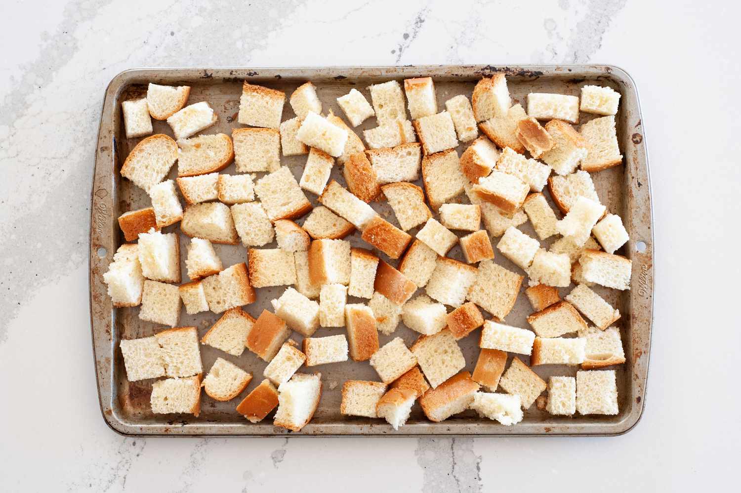 Toasting bread cubes to make mushroom and bacon brioche stuffing