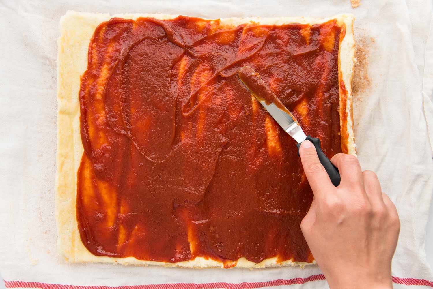 Spreading guava filling on top of a Roll Cake with Guava Jelly