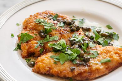 A helping of chicken piccata on a plate topped with sauce