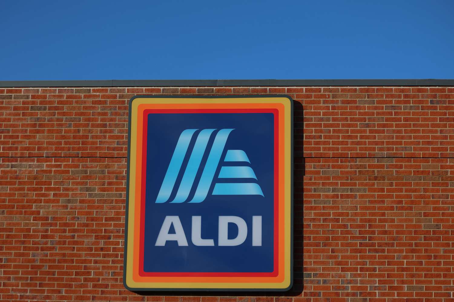 A sign for Aldi on a brick building