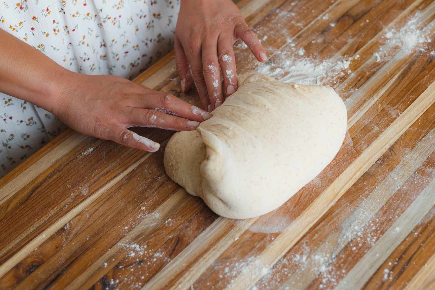 Shaping dough on a counter to make spiced sourdough bread shaped like a pumpkin