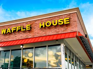 The exterior of a Waffle House restaurant building showing the sign with the name and large windows