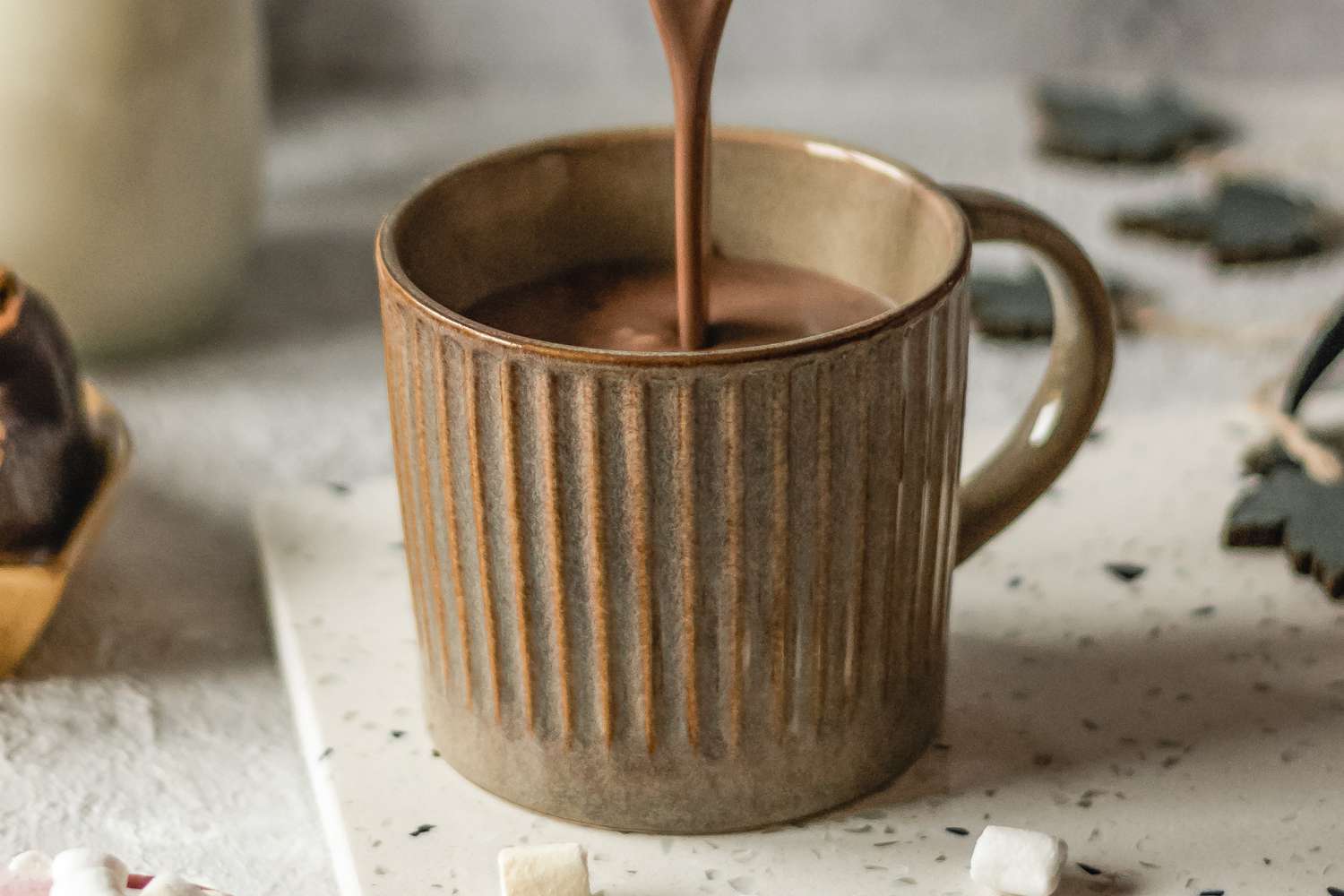 Growing up the weakling in a family of winterproof skiers, hot chocolate was my parents’ way of softening the blow of a good blizzard. Daily stops at the hot chocolate machine were encouraged. If food is a love language, hot chocolate translated to a liquid apology: I’m sorry you got so cold, kid. Still today, older and sturdier, it’s the soothing balm I make myself when the mercury drops. But for today’s thawing-out episodes, I always give hot chocolate a crucial upgrade: I stir in a knob of butter. Adding butter makes it richer and a bit more viscous, transforming my simple self-care ritual into something downright indulgent. Adult me puts hot chocolate (always “hot chocolate” to me, never “hot cocoa”) into three categories. On the lower end, there’s the powdered variety, which includes both the lifesaving little packets and the big ski-lodge machines that nursed me through childhood. At the high end, there’s Euro-style drinking chocolate, which is basically melted chocolate bars that you sip until your eyes roll back. In the middle, there’s my Goldilocks, an easy homemade hot chocolate: I stir together a cup of semisweet chocolate chips with two cups of milk and whisk it in a pan over low heat until all the chocolate has melted. But while the homemade kind only takes a minute longer than opening a paper envelope of instant powder, not all cold-toed emergencies occur in a stocked kitchen. So realistically, I usually rely on the instant type, which butter elevates, no matter what brand of hot chocolate you’re using. How to Add Butter to Hot Chocolate (and Which Butter is Best) The butter trick adds noticeably deeper chocolate flavor to even the most anemic powdered packet—just drop a bit of butter into a mug with the chocolate powder, then add the boiling water and stir until the butter melts. While any butter makes instant hot chocolate better, not all butter is created equal. I prefer salted butter, which enhances the taste of the chocolate itself a bit more, but my teen likes unsalted butter, because it boosts body and flavor without tamping down any existing sweetness. Enough tinkering has taught me that I prefer adding about two teaspoons of butter to an 8-ounce cup—any less doesn’t add quite the same decadence, and any more makes the hot chocolate really taste like butter. Curiously, it’s also the amount of butter in one of those pre-packaged butter pats at a ski lodge baked potato bar. But I didn’t tell you that.