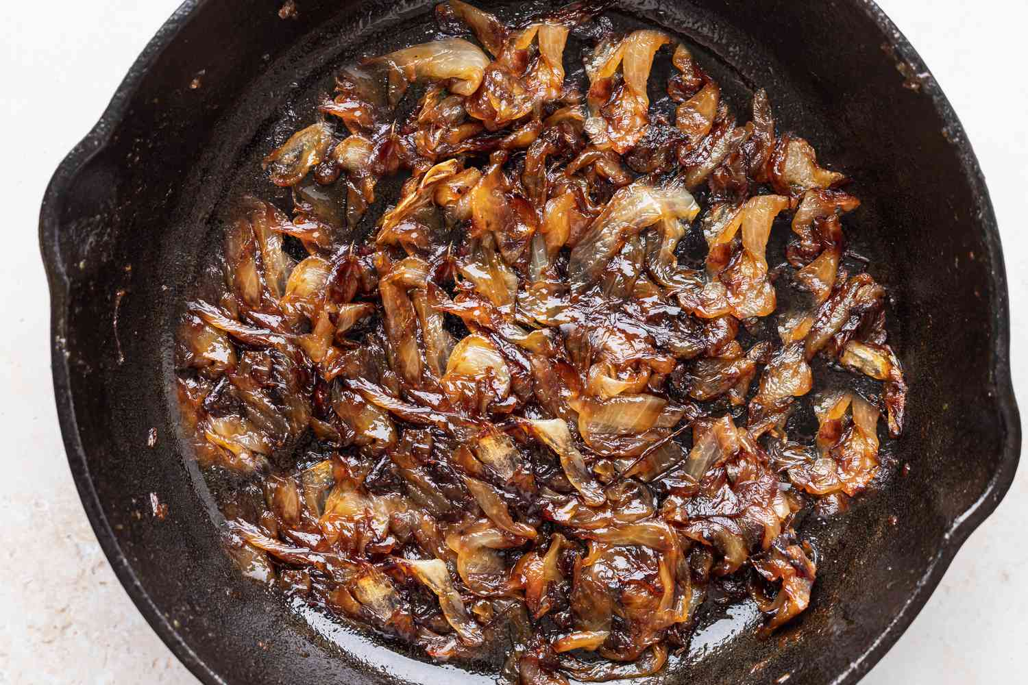 Overhead view of a cast iron skillet filled with caramelized onions
