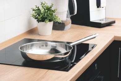 A stainless steel frying pan on an electric stovetop