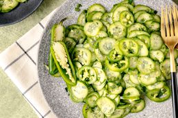 Spicy Cucumber and Jalapeno Salad on a Plate with a Halved Jalapeno and Utensils 