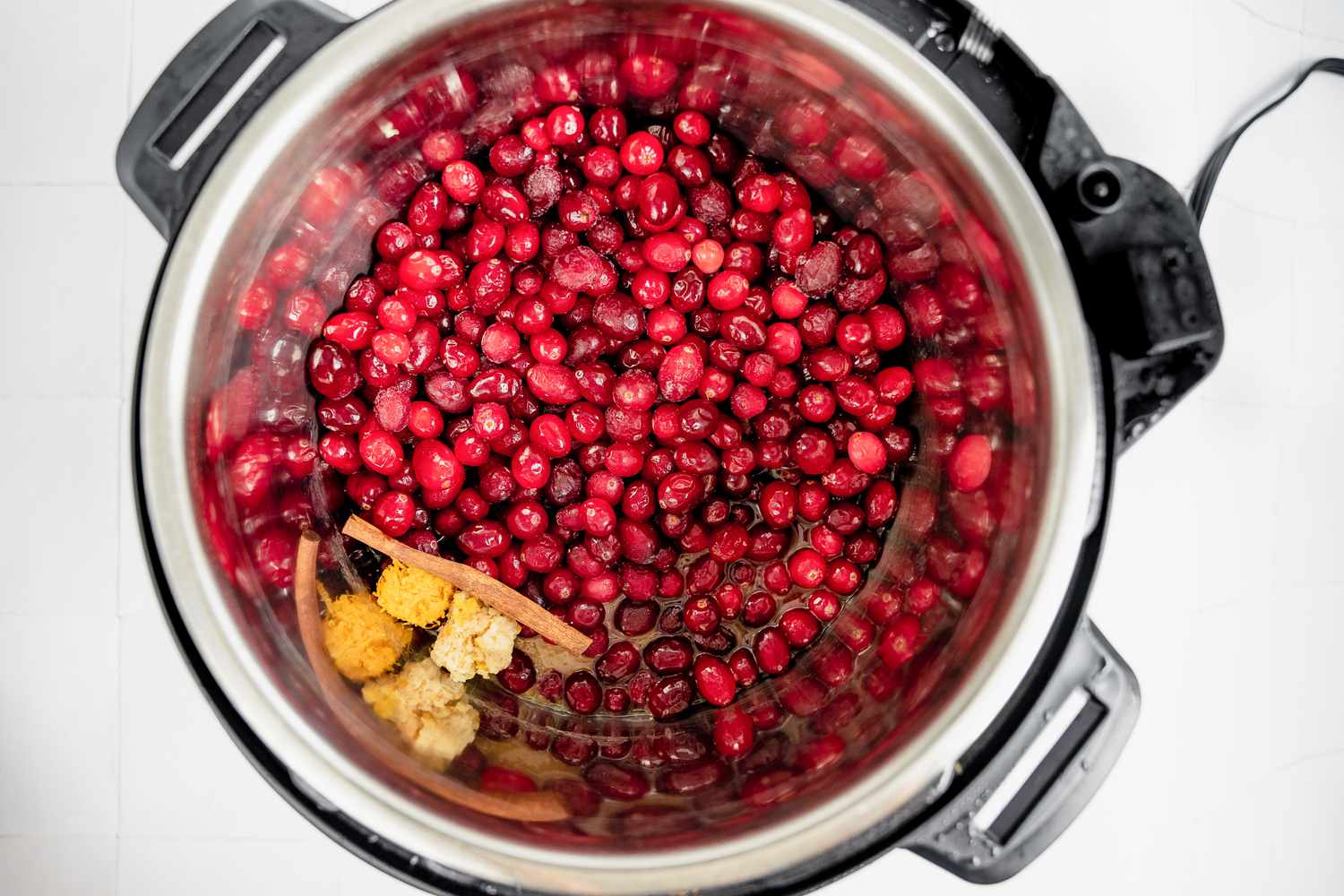 Cranberries, Cinnamon Stick, Ginger, and Orange Zest in an Instant Pot for Instant Pot Cranberry Sauce Recipe