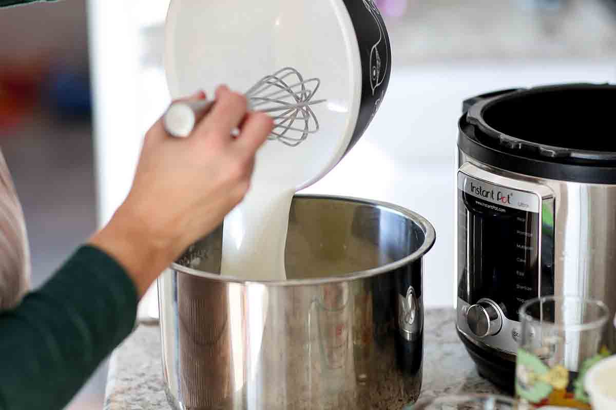 whisked milk being poured into a pressure cooker