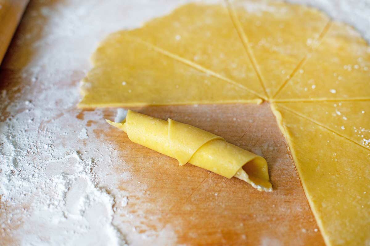 Rolling Butterhorn Christmas Cookies on a floured surface.