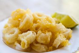 Tempura Fried Calamari on a plate with lime wedges on the side