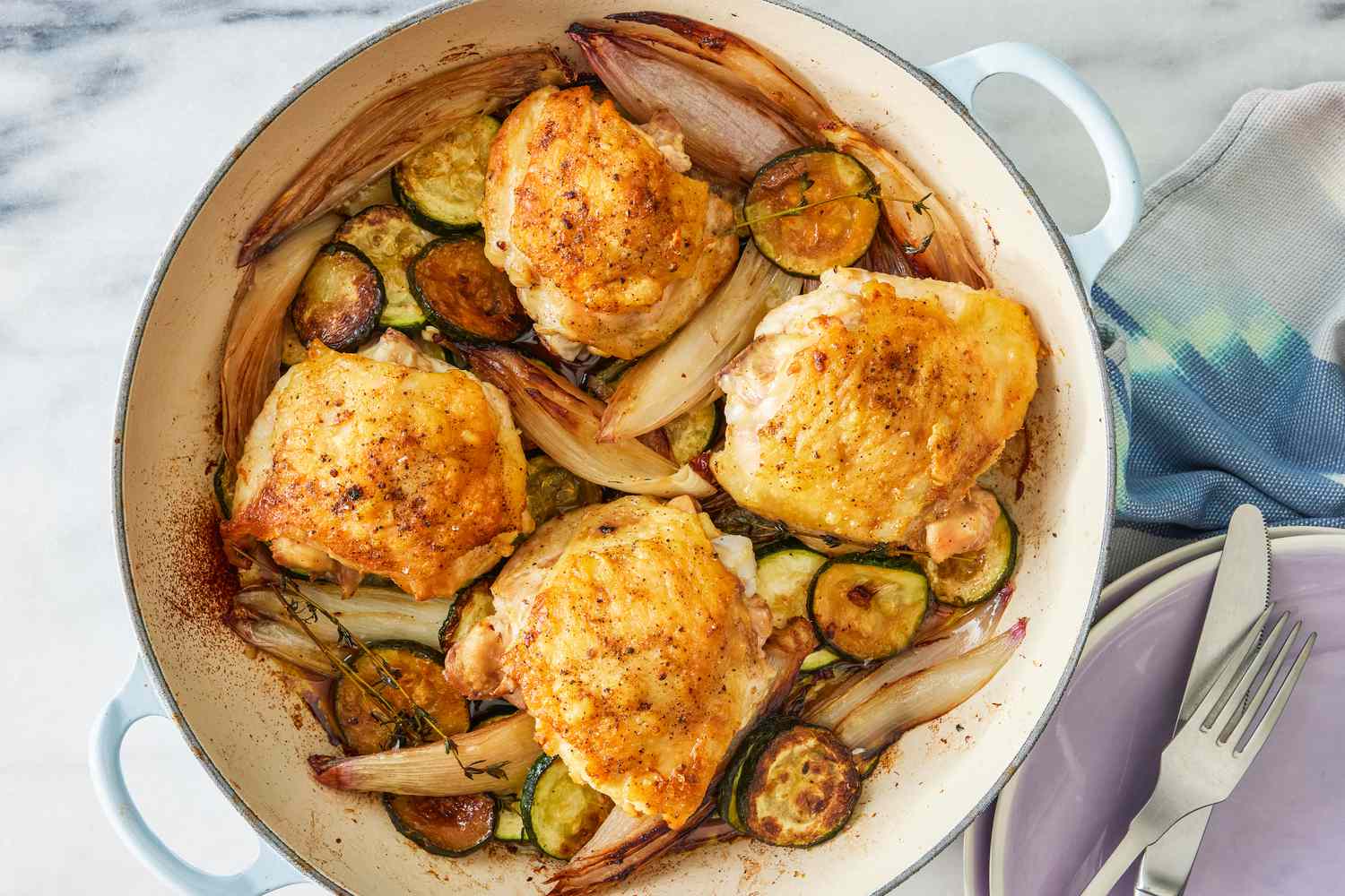 crispy chicken thighs with zucchini and shallots in a dutch oven