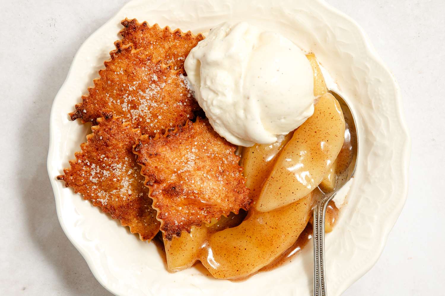 short-cut apple pie and a dollop of vanilla ice cream in a bowl with a spoon