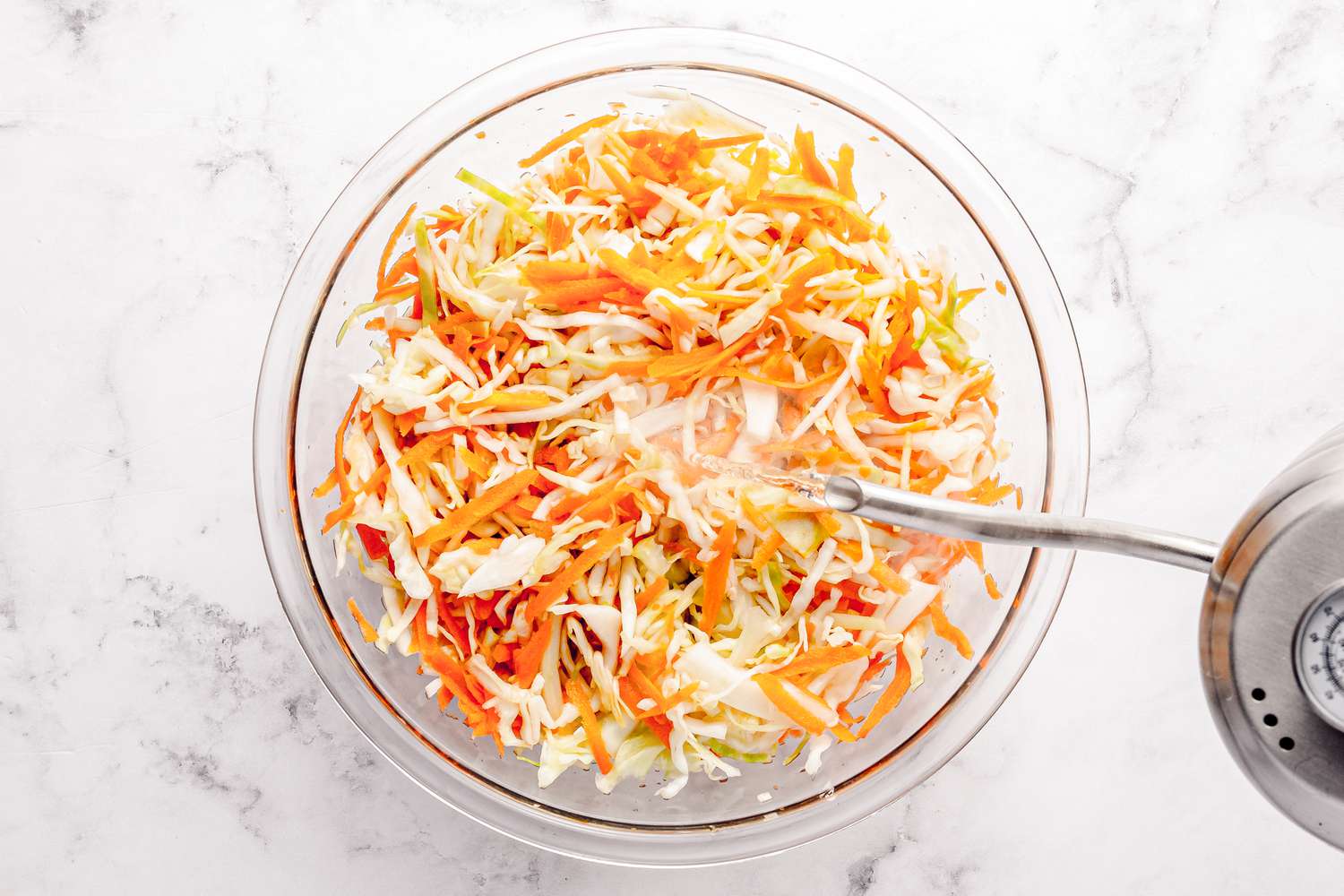 Boiling Water Added to a Bowl of Shredded Cabbage and Carrots