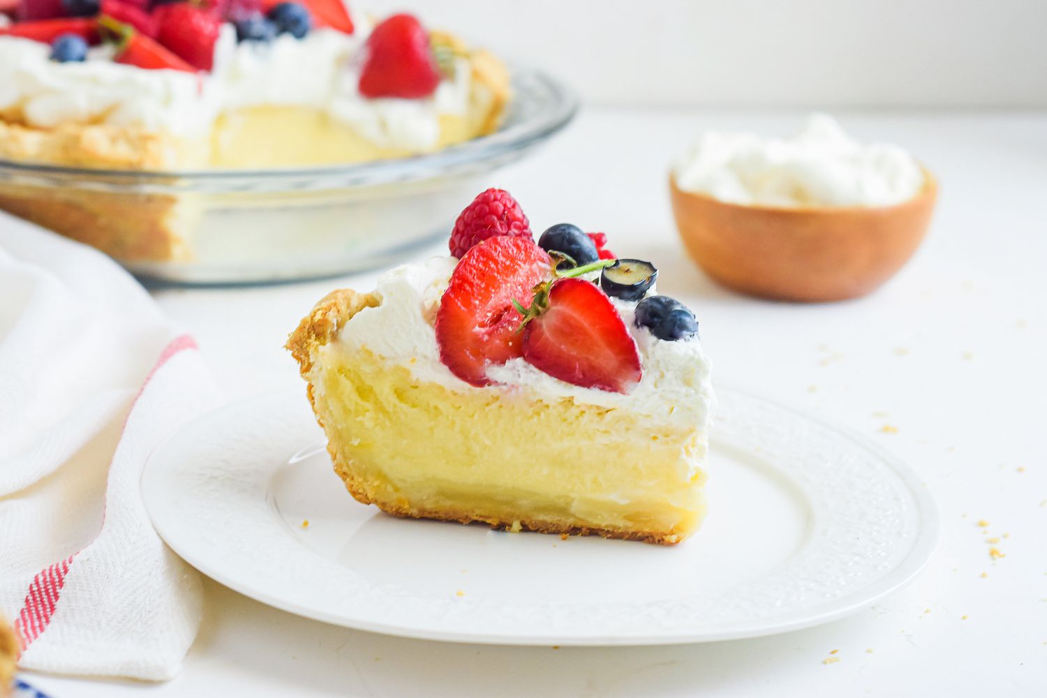 A slice of buttermilk pie set in front of the whole pie.