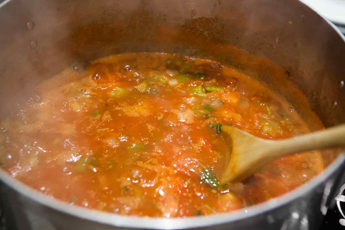 combining and boiling ingredients for salsa recipe for canning