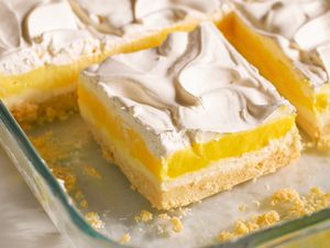A dessert with layers of crust, lemon filling, and whipped topping in a baking dish