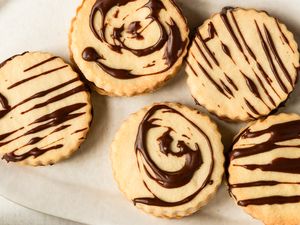 Round cookies decorated with chocolate patterns displayed on a surface