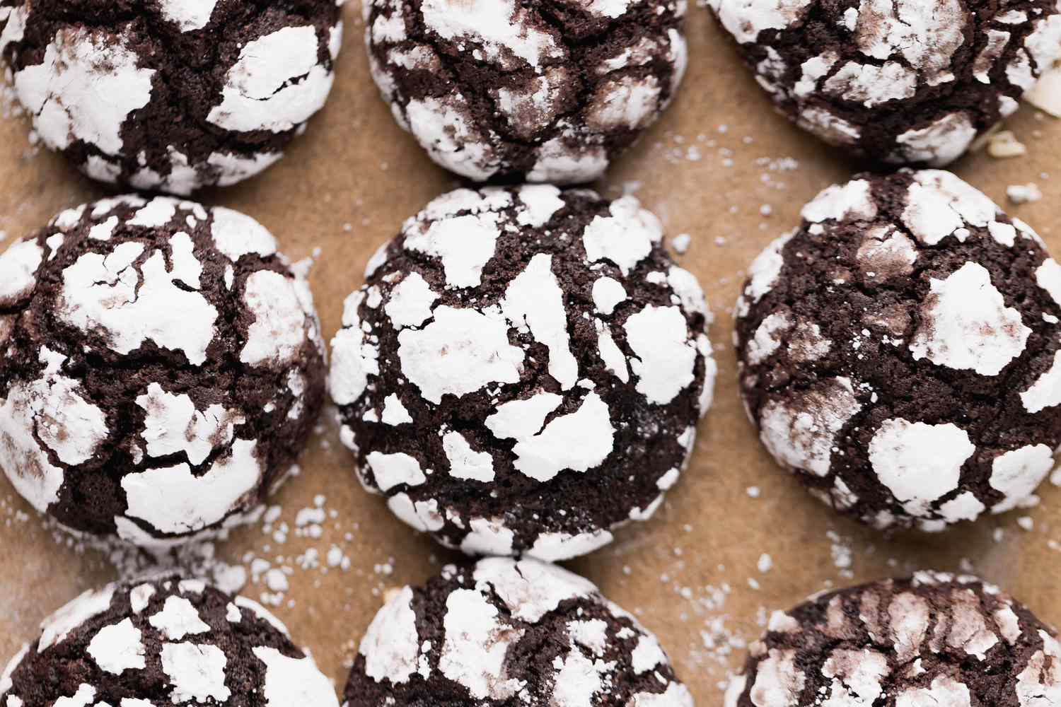 Overhead view of chocolate crinkle cookies on a lined baking pan
