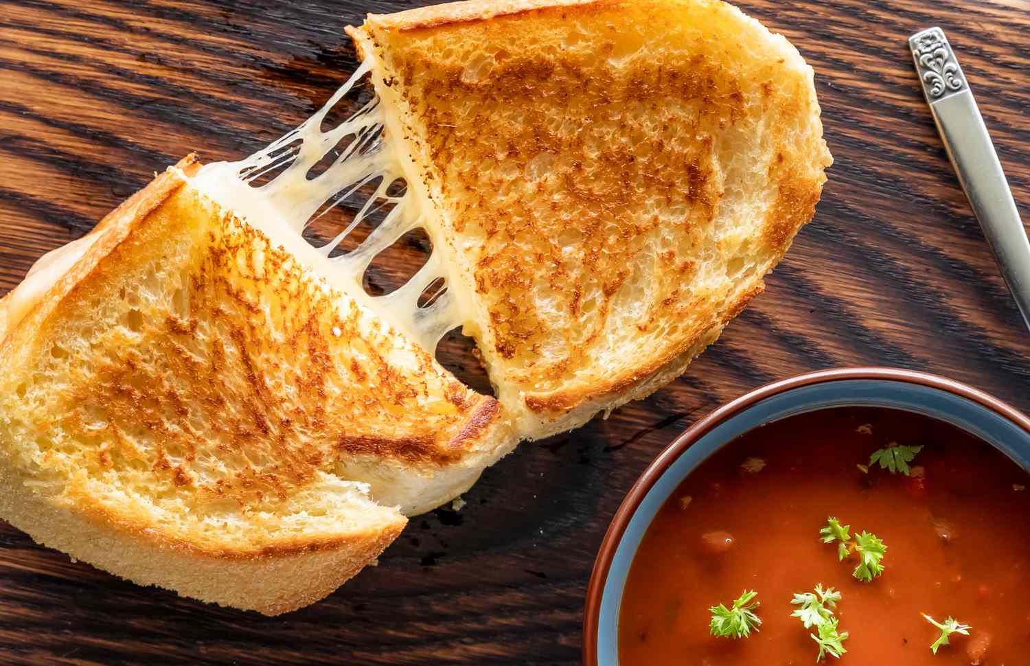 A grilled cheese being pulled apart, showing the gooey melted cheese
