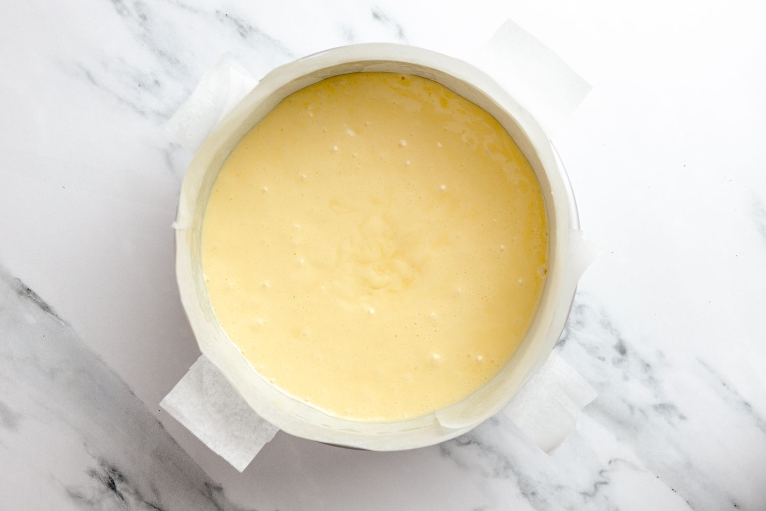 Japanese Cheesecake Batter Added to Parchment Paper Lined Round Cake Pan 