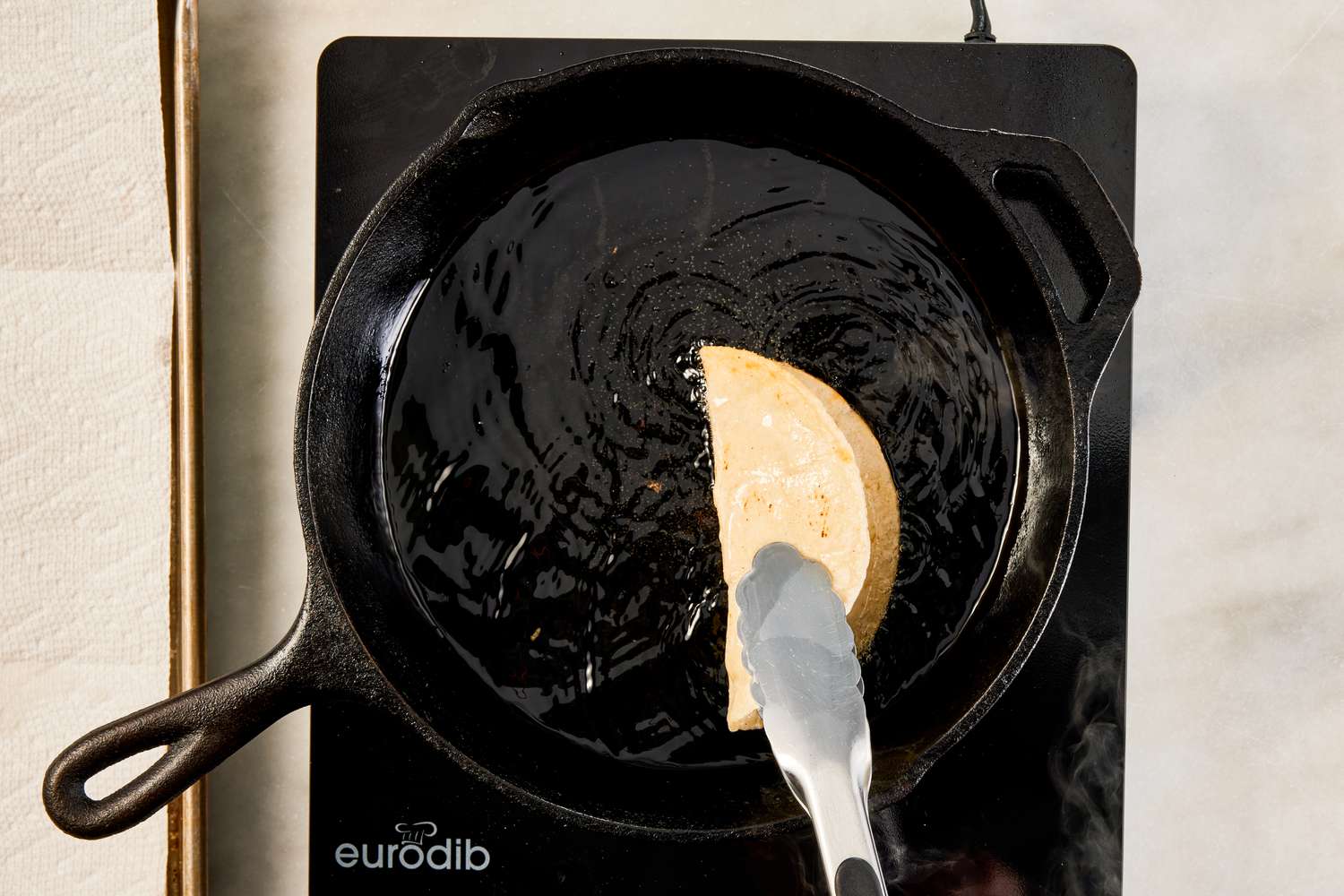 corn tortilla folded in half while fried in cast iron skillet for crispy ground beef recipe