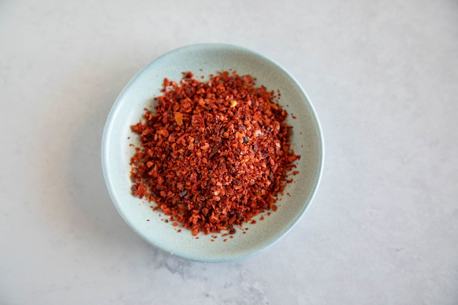 Aleppo pepper flakes in a light blue bowl