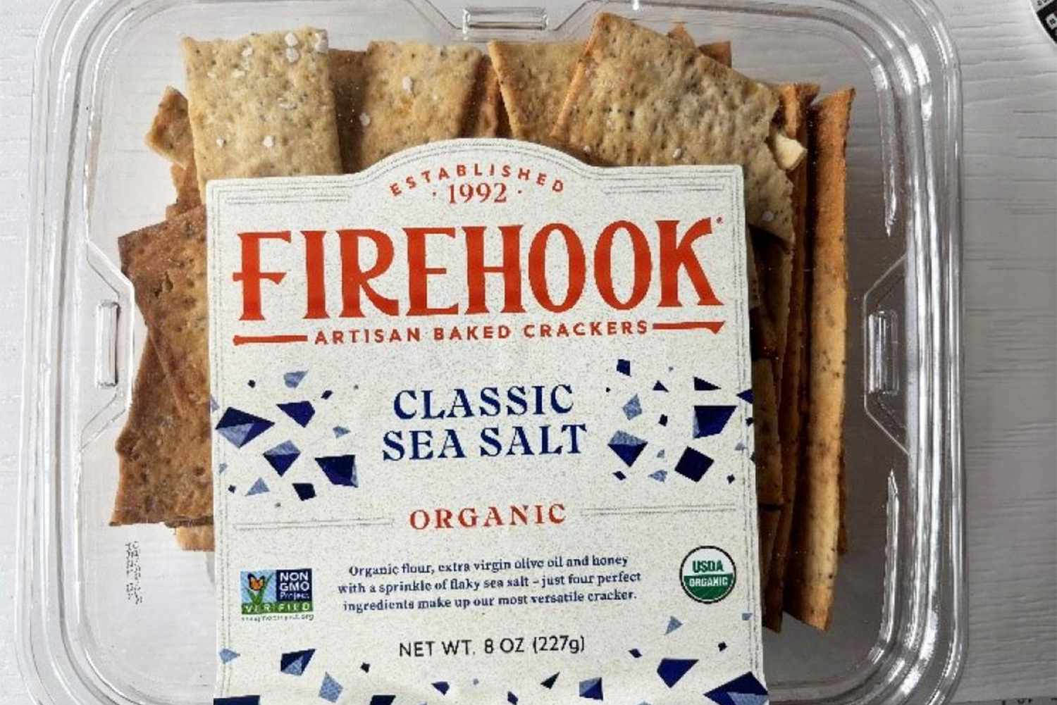 Packaging for Firehook Artisan Baked Crackers, Classic Sea Salt flavor, in a plastic container with crackers inside