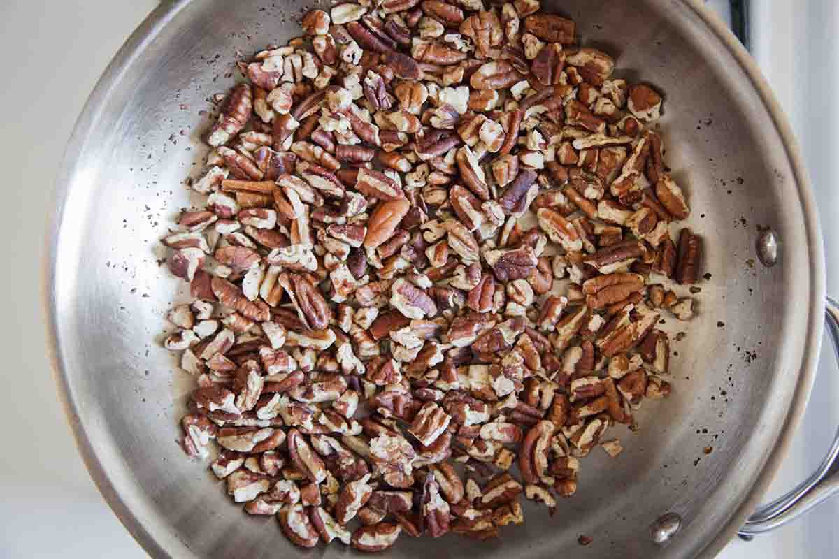 Overhead of pecans toasting in a pan