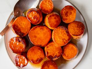 A plate of glazed sweet potato rounds served with a spoon