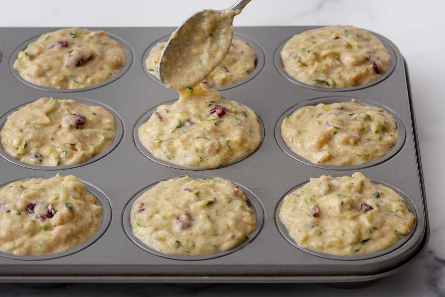 Spooning batter into a muffin tin