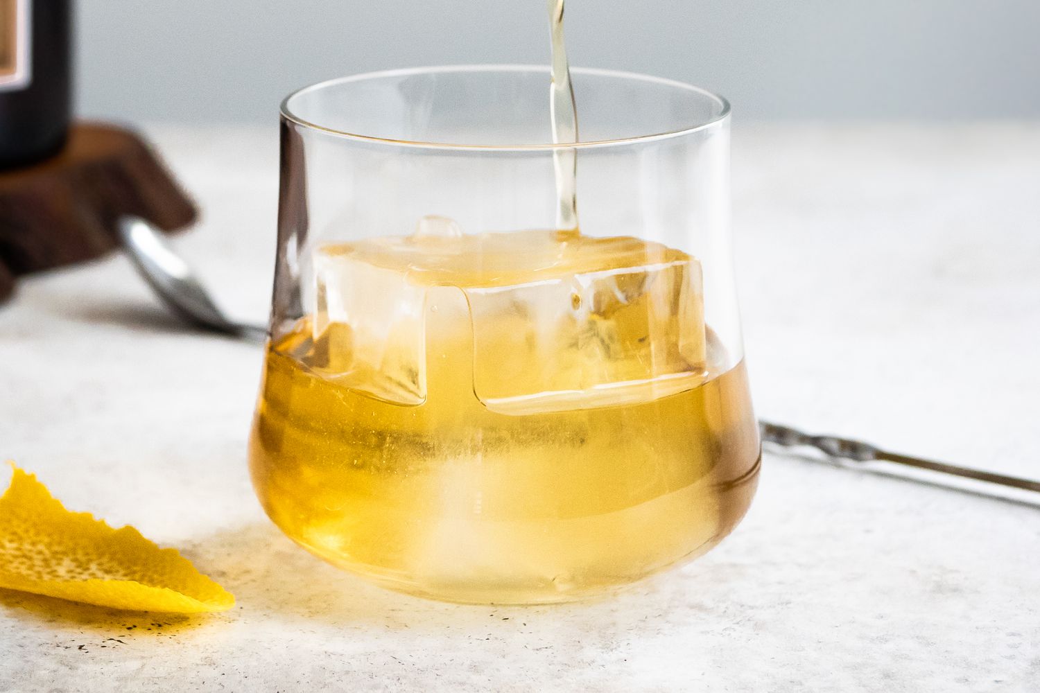 Rusty Nail Poured into a Glass with an Ice Cube