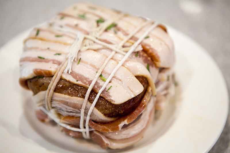 Bacon wrapped pork roast tied with twine