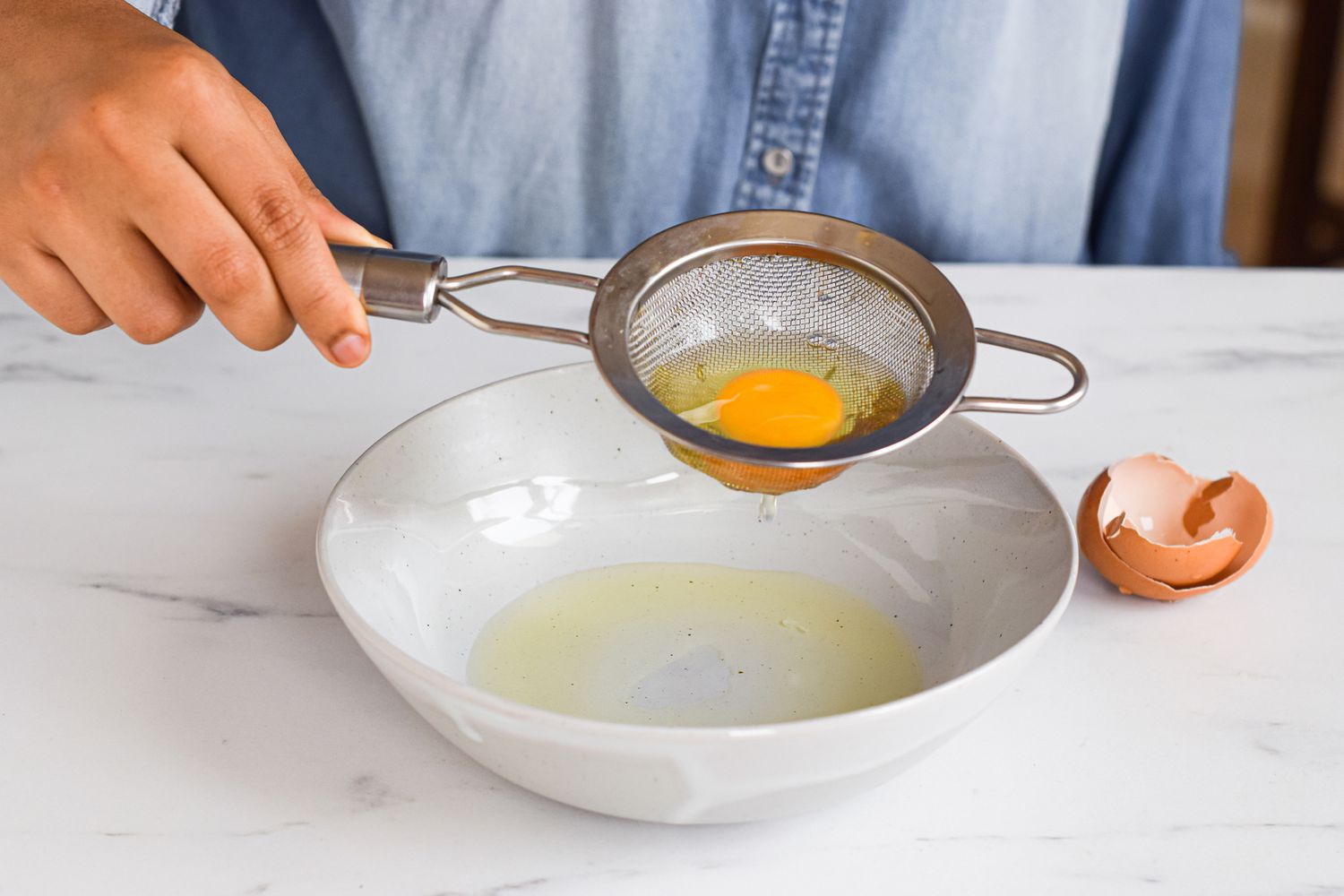 A cracked egg in a sifter.