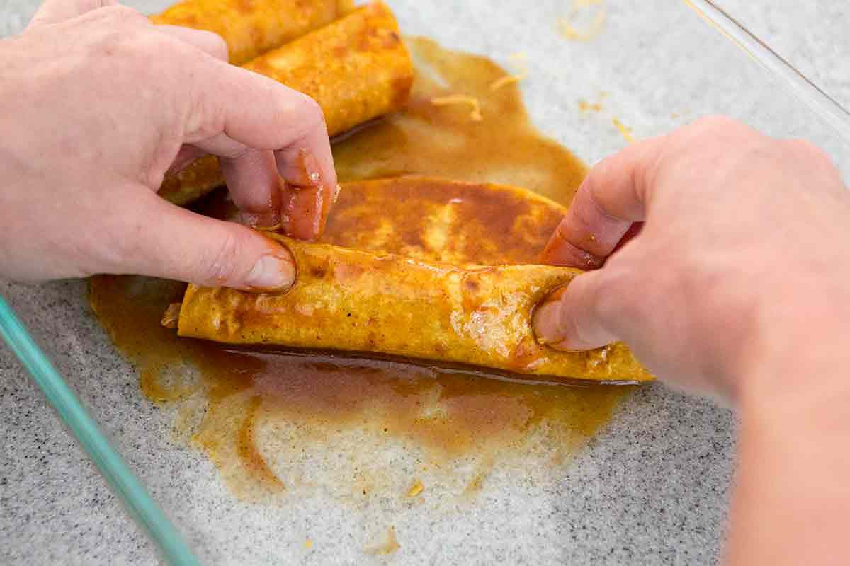 roll up the stuffed tortillas to make this easy chicken enchiladas casserole