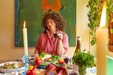 Zoe Kormarin sitting at a Passover table with lit candles
