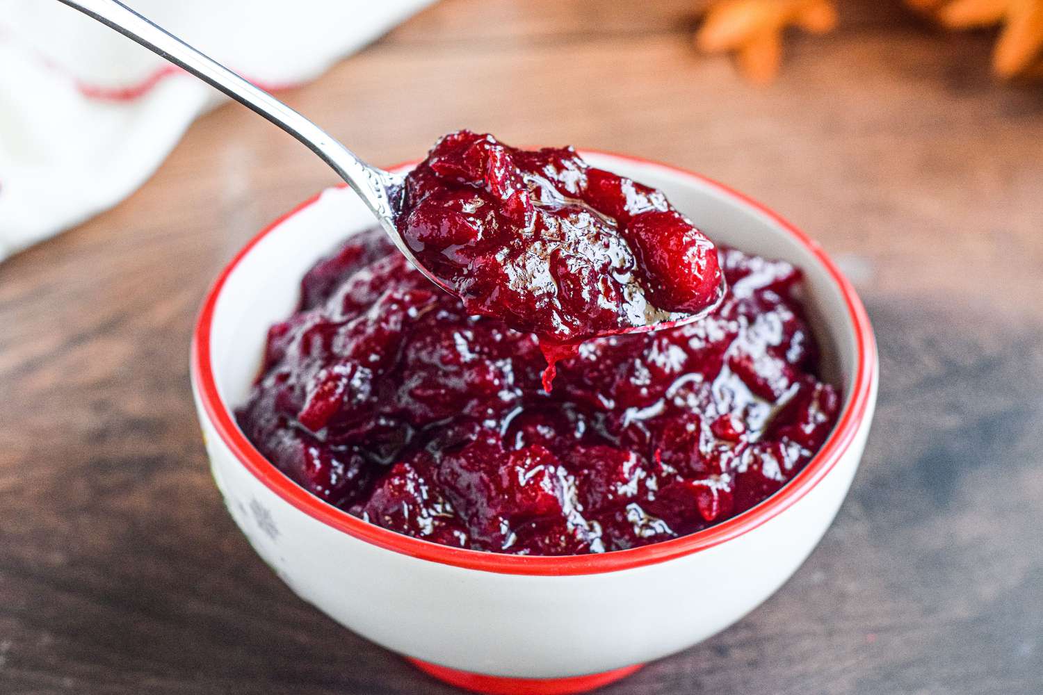 cranberry sauce in a bowl with a spoonful hovering above it